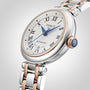 A close-up of a Tissot Bellissima Automatic wristwatch with a silver and rose gold metal band, white dial, blue hands, and Roman numeral hour markers—showcasing the luxury and style Tissot is known for.