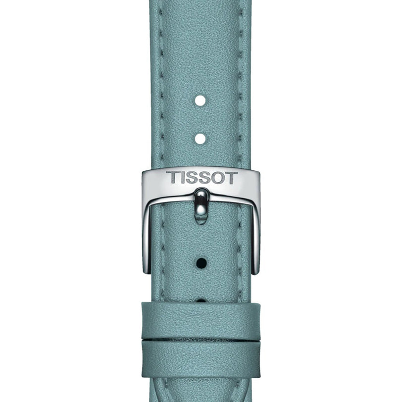 Close-up of a light blue leather strap with a silver buckle engraved Tissot, showcasing the refined elegance of the Tissot Carson Premium Moonphase watch.