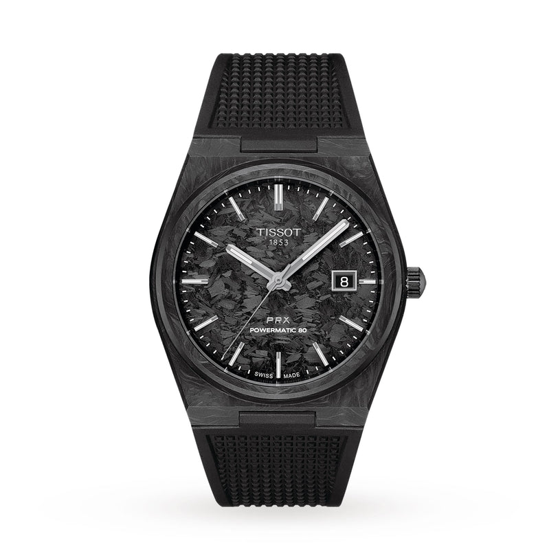 A Tissot PRX Powermatic 80 Carbon watch featuring a textured black dial, date display, and black rubber strap is displayed on a white background.
