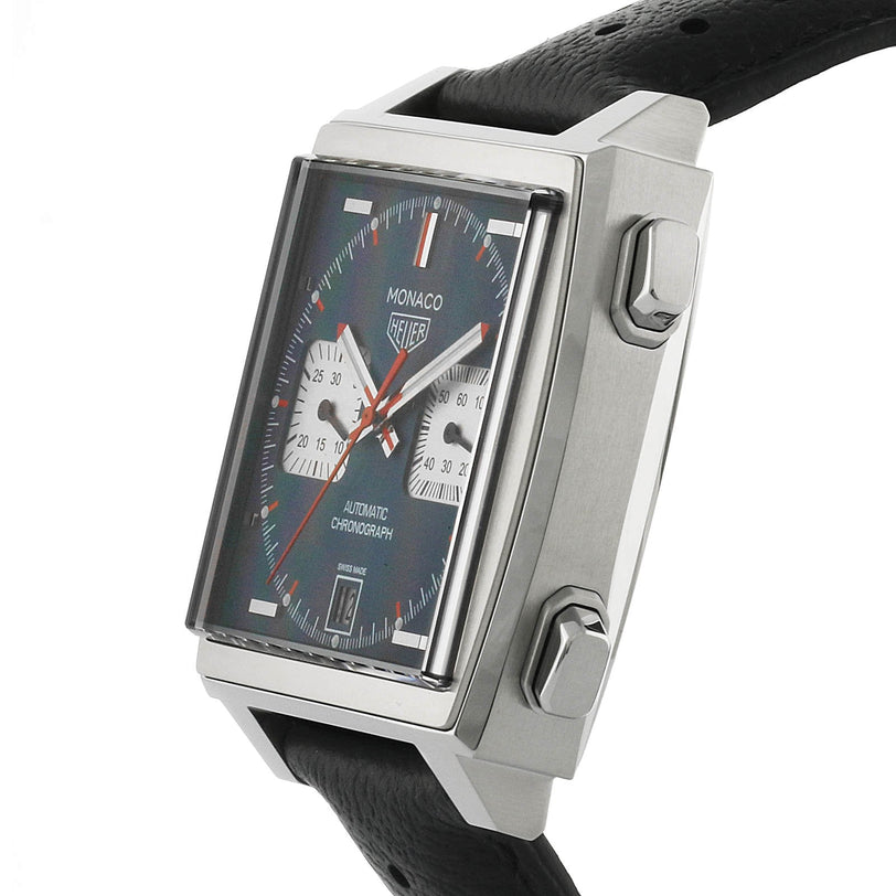 The TAG Heuer Monaco Chronograph is a square watch inspired by Steve McQueen, featuring a black strap, side buttons, black dial with two subdials, date display, and calibre 11 automatic movement.
