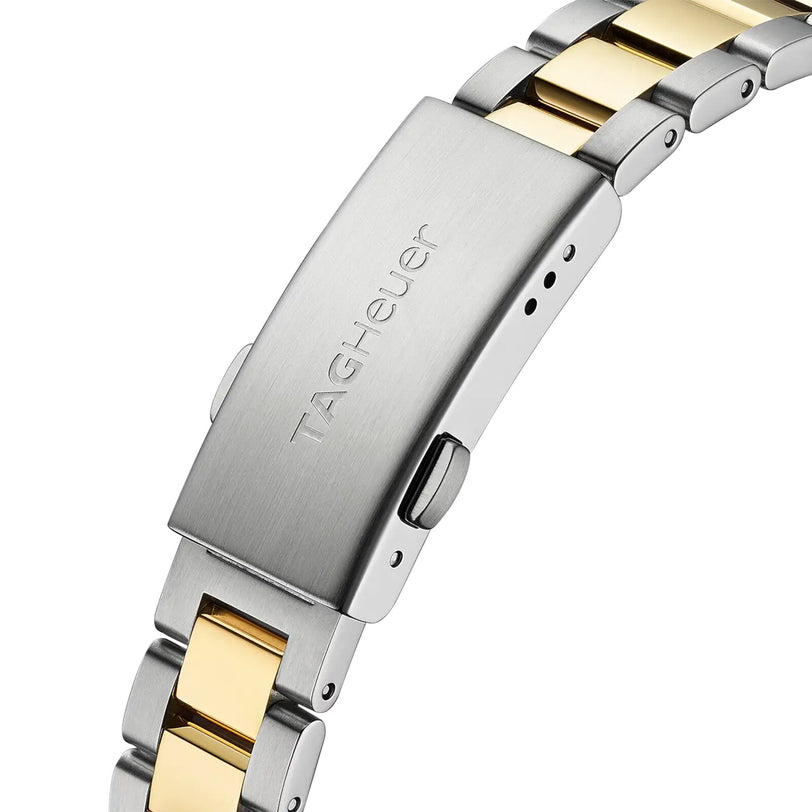 Close-up of a TAG Heuer Aquaracer Date clasp with a brushed finish, showing silver and gold stainless steel links and the engraved TAG Heuer logo.
