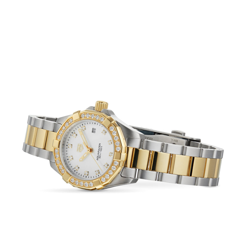 The TAG Heuer Aquaracer Date wristwatch features a stainless steel and 18K gold two-tone case, white dial, diamond bezel, and metal link band, displayed at an angle against a white background.
