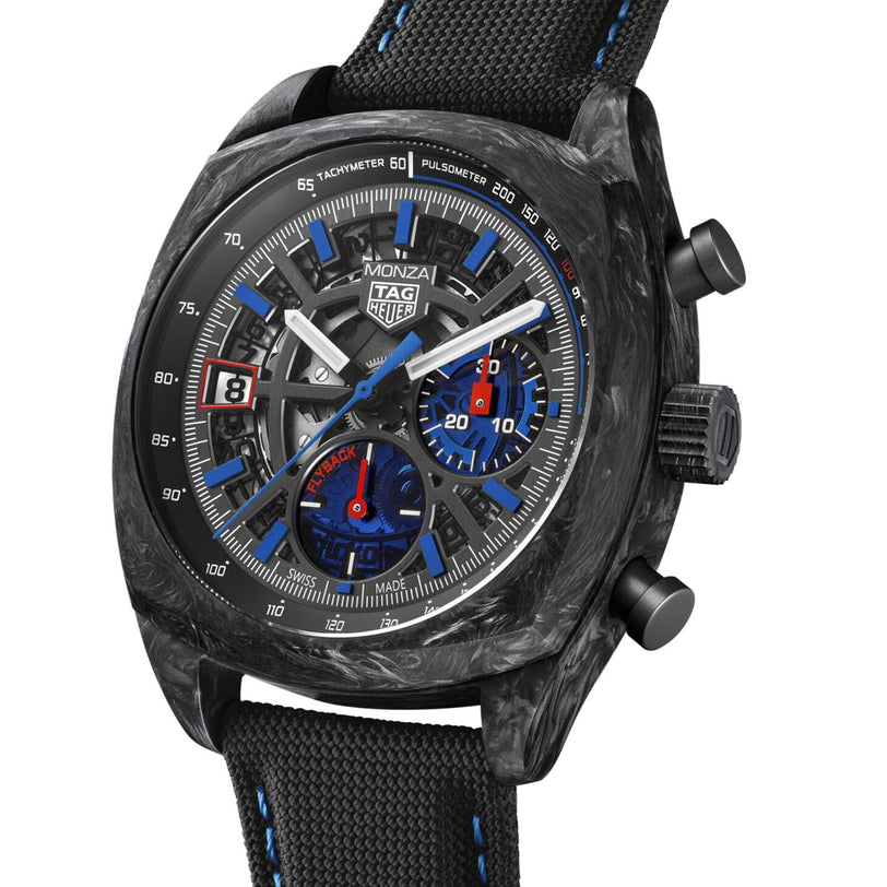 The TAG Heuer Monza Flyback Chronometer features a black carbon case, blue and red chronograph subdials, tachymeter and pulsometer scales, and a black fabric strap, all inspired by competition motorsports.