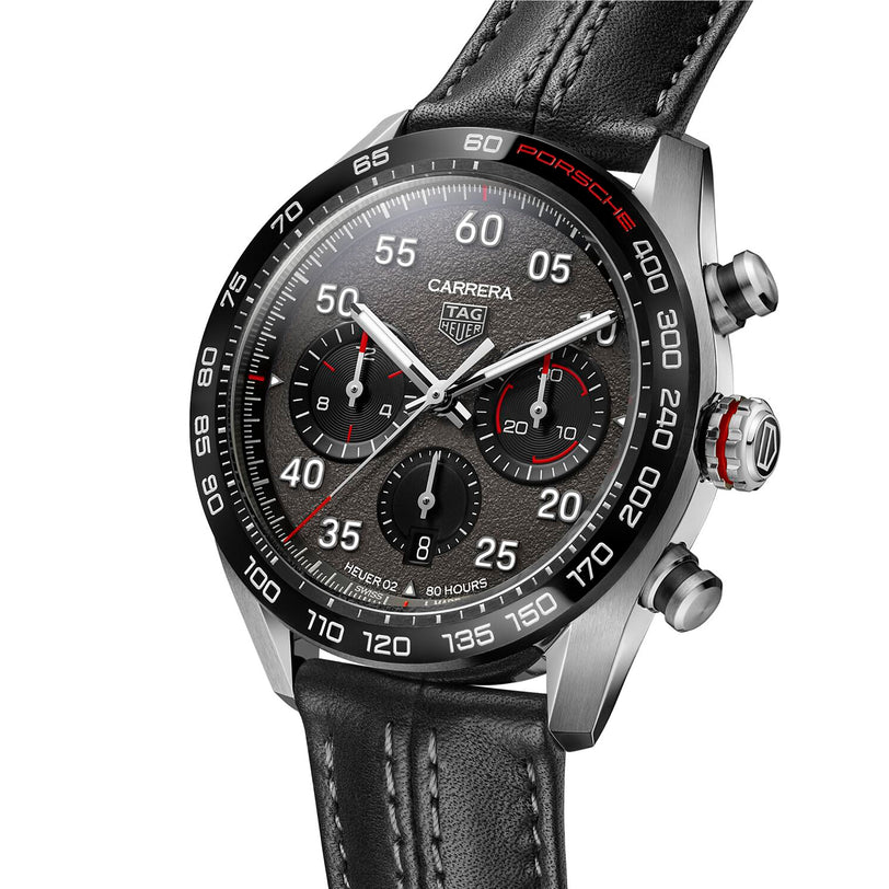 Close-up of the TAG Heuer Special Edition Carrera Chronograph x Porsche, featuring a black dial with red accents, black leather strap, and a bezel with bold Porsche branding.