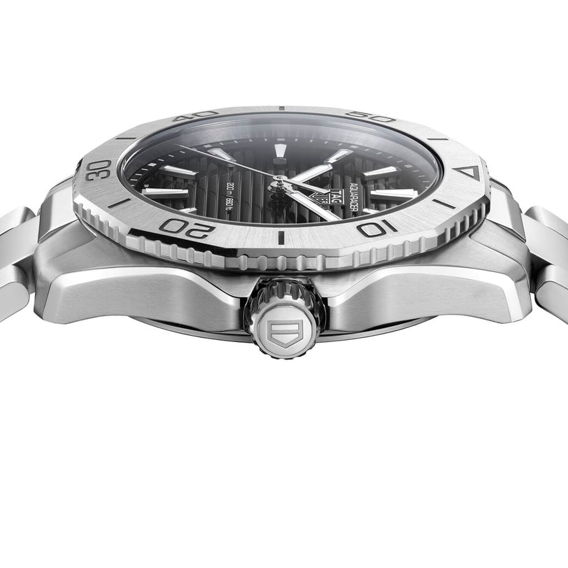Side view of the TAG Heuer Aquaracer Professional 200, a stainless steel sports watch with ridged bezel, black dial, and metal bracelet, highlighting the crown and case details inspired by the Aquaracer collection.