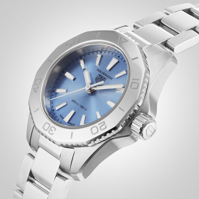 The TAG Heuer Aquaracer Professional 200 is a silver wristwatch with a blue face, silver hour markers, and a metal band, displayed at an angle on a white background.