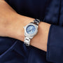 A person in a dark blue long-sleeve shirt wears a TAG Heuer Aquaracer Professional 200, featuring a blue face and stainless steel case.