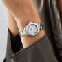 A person in a dark long-sleeve shirt wears a TAG Heuer Aquaracer Professional 200, featuring a stainless steel case and white face.
