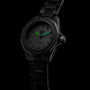 The TAG Heuer Aquaracer Professional 200, a black sports watch with a diamond bezel, luminous green and blue hands, diamond hour markers, and a black metal bracelet, is displayed against a dark background.