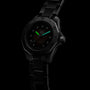 A TAG Heuer Aquaracer Professional 200 Date wristwatch with a stainless steel case and metal band glows in low light, showcasing its luminous green hour and minute hands.