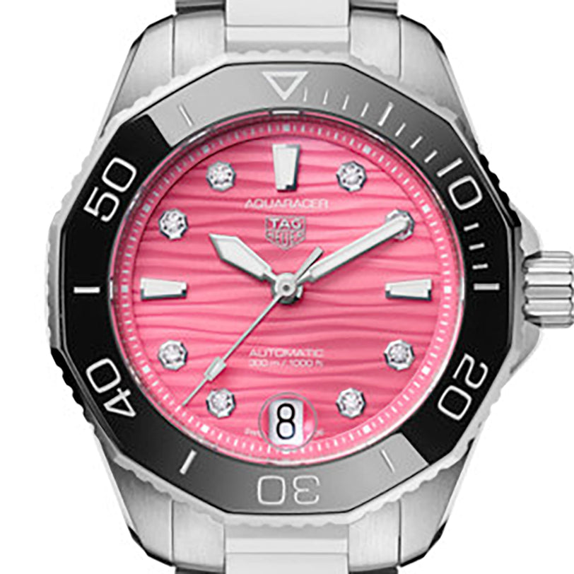 The TAG Heuer Aquaracer Professional 300 Date is a stylish dive watch with a stainless steel case, black bezel, pink textured dial featuring diamond hour markers, and a date window at 6 o’clock.