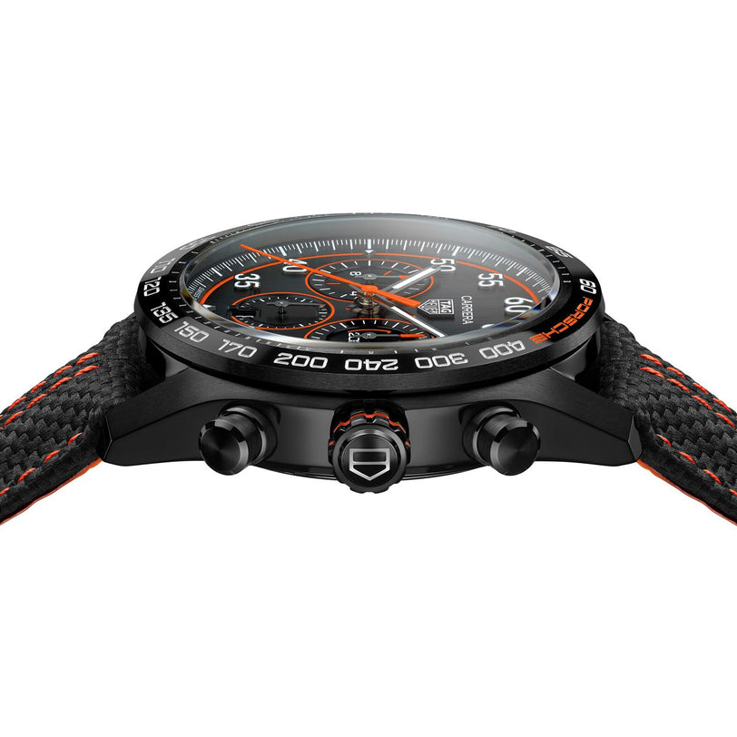 Side view of the TAG Heuer Special Edition Carrera Chronograph x Porsche Orange Racing watch in black, showcasing orange accents, a textured strap, and prominent control buttons.