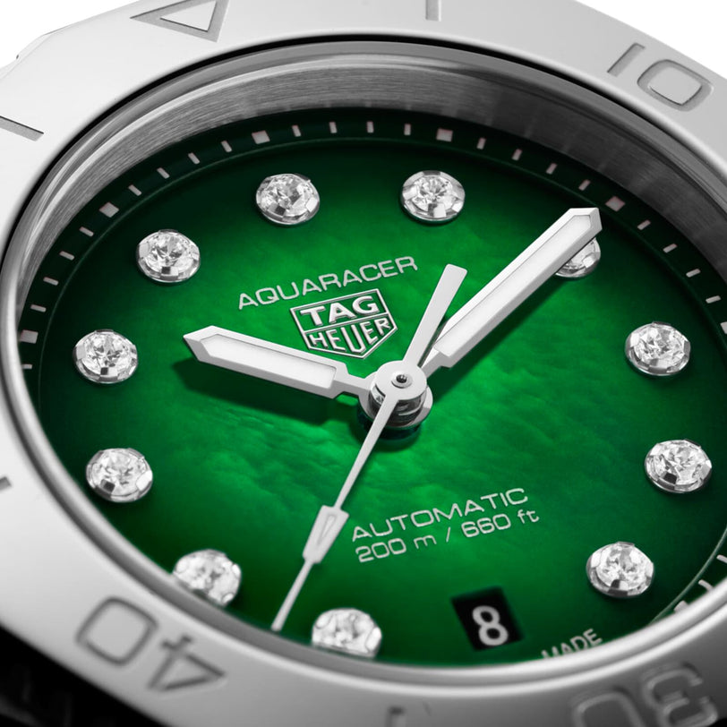 Close-up of the TAG Heuer Aquaracer Professional 200 sports watch featuring a green dial, diamond hour markers, silver hands, and a date window set to the 8th. Water resistance is rated at 200 m / 660 ft.