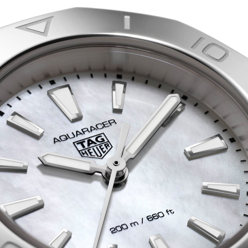 Close-up of a TAG Heuer Aquaracer Professional 200 watch face, featuring silver hour markers, hands, and branding, with 200-meter (660 ft) water resistance shown and reliable quartz movement.