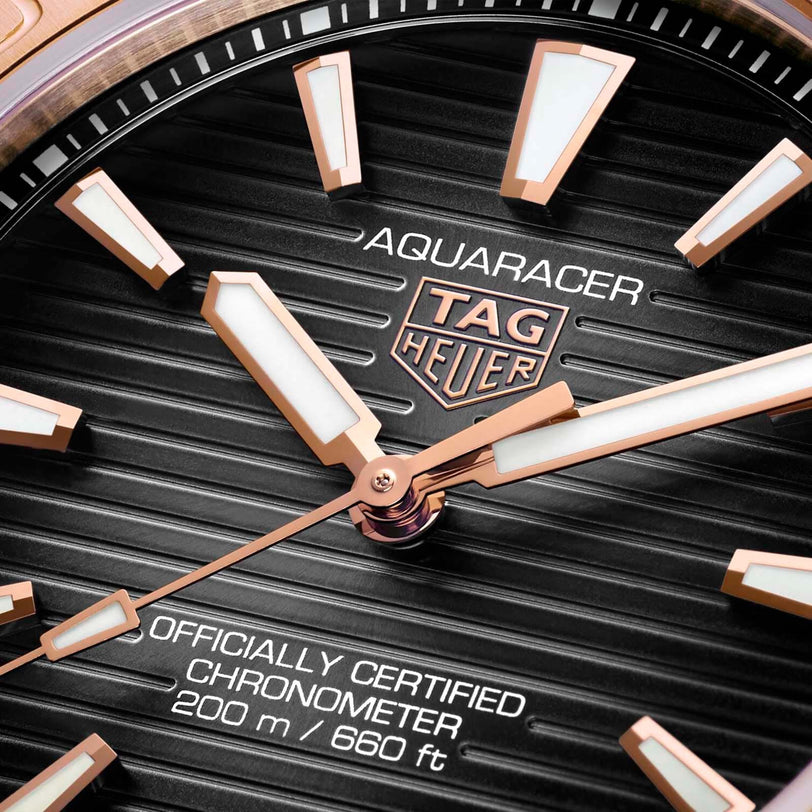 Close-up of the TAG Heuer Aquaracer Professional 200 watch face with rose gold hands, hour markers, branding, and Officially Certified Chronometer 200m/660ft text. Powered by the precise TH31-00 calibre movement.