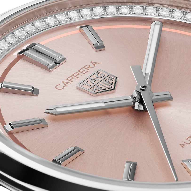 Close-up of the TAG Heuer Carrera Date watch face featuring a rose gold background, silver hour markers, crystal accents, and visible hour, minute, and second hands powered by an automatic movement.