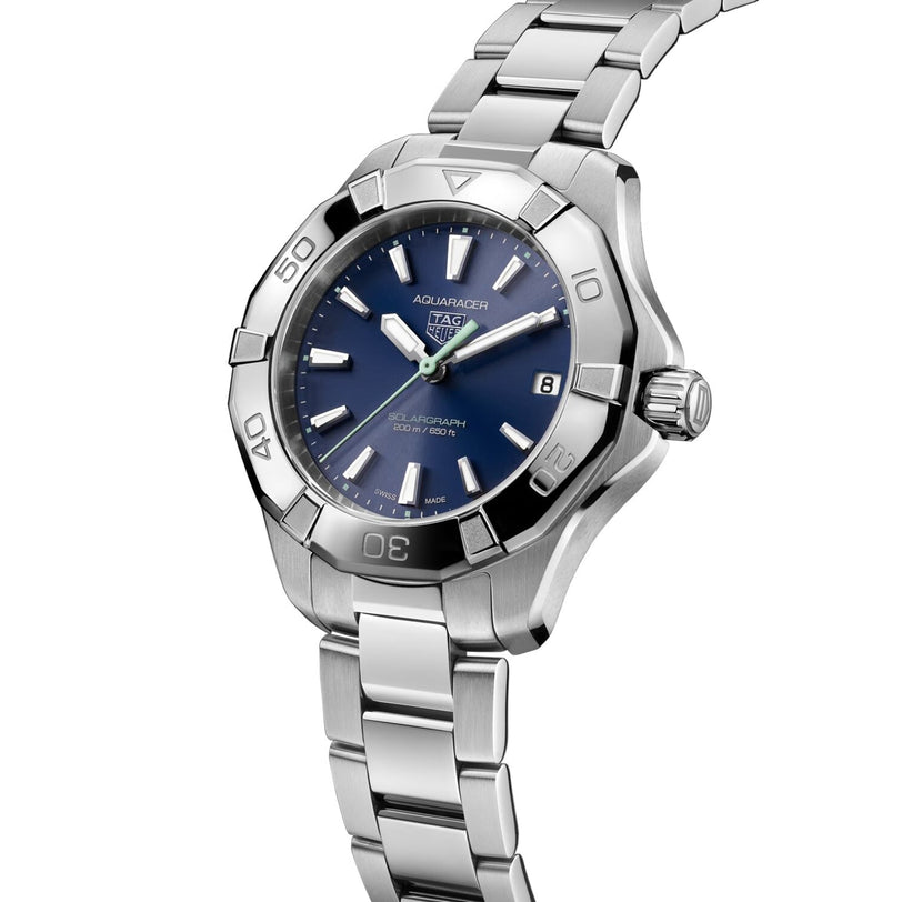 The TAG Heuer Aquaracer 200 Professional Solargraph is a stainless steel sports watch with a blue dial, silver hour markers, date display at 3 o’clock, and a metal link bracelet.