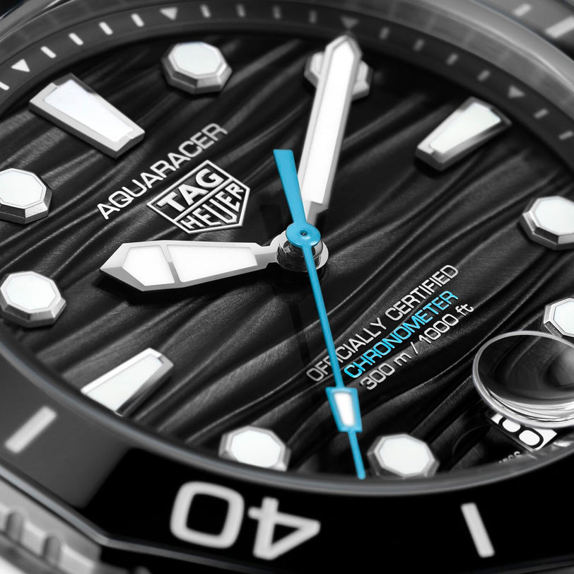 Close-up of a TAG Heuer Aquaracer Professional 300 Date watch face, highlighting the brand logo, hour markers, hands, and 300m/1000ft certification—an elegant luxury timepiece from TAG Heuer.