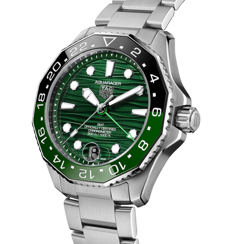 The TAG Heuer Aquaracer Professional 300 GMT features a green dial, black and green bezel, stainless steel bracelet, and displays both time and date.