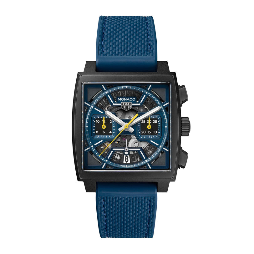 The TAG Heuer Monaco Chronograph features a square face, titanium case, skeleton dial, blue strap, and blue and yellow accents with visible internal mechanisms.