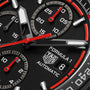 Close-up of the TAG Heuer Formula 1 Chronograph watch face, featuring red, white, and black accents with detailed subdials, a date window, and bold motorsport-inspired elements.