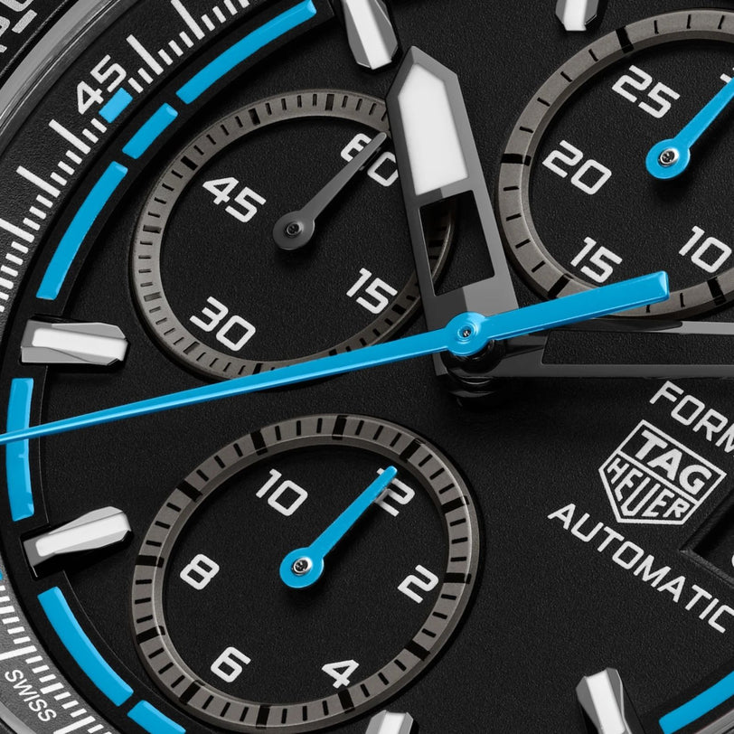 Close-up of the TAG Heuer Formula 1 Chronograph watch face, displaying multiple subdials, blue accents, a tachymeter bezel, and luminescent hands.