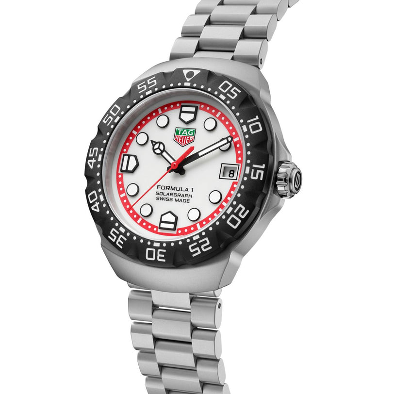 The TAG Heuer Formula 1 Solargraph features a silver case, white dial, black bezel, red accents, and a metal bracelet.