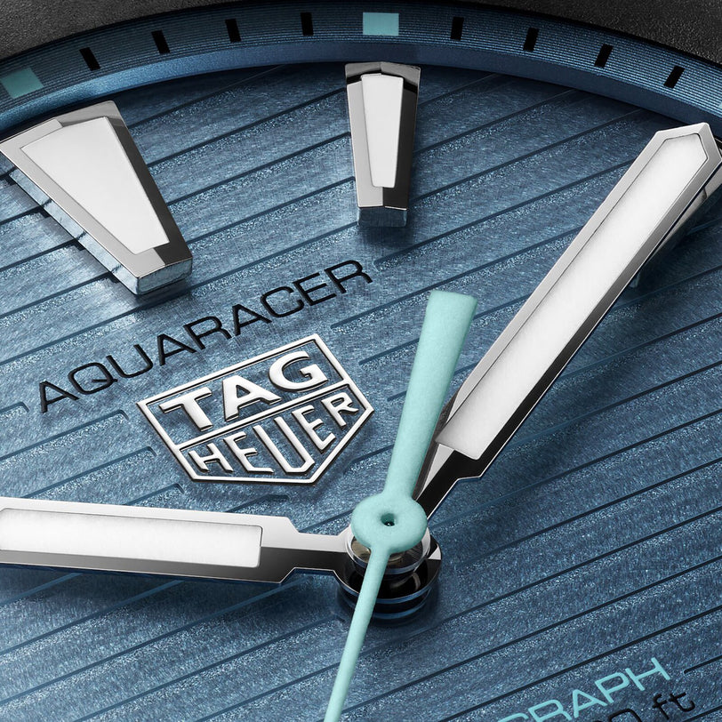 Close-up of a blue TAG Heuer Aquaracer Professional 200 Solargraph watch face, highlighting the hands, markers, and logo.