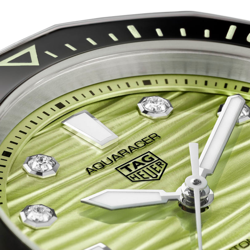 Close-up of a TAG Heuer L SS AU BW AQUAR 300 36 GRN DD DL 25 watch featuring a green textured dial with diamond hour markers.