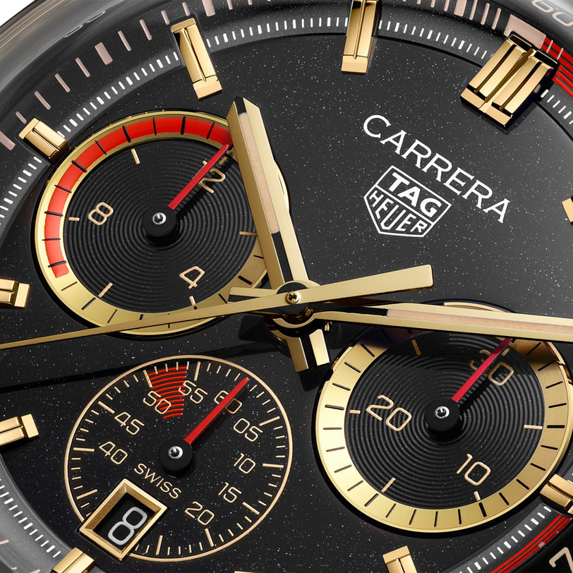 Close-up of the TAG Heuer Carrera Chronosprint x Porsche Rallye watch face featuring gold accents, subdials, and red details on the hands.