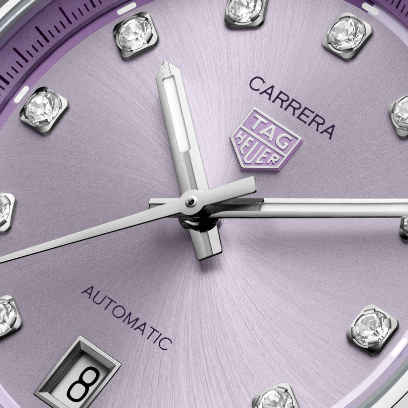 Close-up of a purple TAG Heuer Carrera Date watch face featuring diamond hour markers and a date display at 6 o’clock.