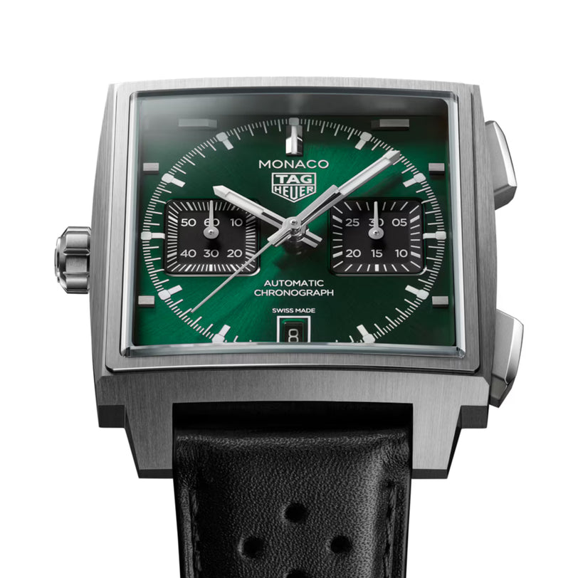 Square stainless steel chronograph watch with green dial, black subdials, white hands, and black perforated rubber strap.