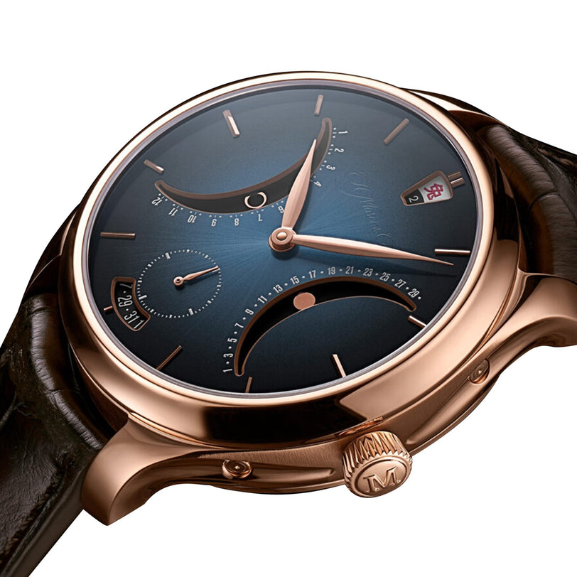 The Endeavour Chinese Calendar by H. Moser & Cie is a luxury wristwatch with a blue dial, rose gold case, black leather strap, and multiple dials.