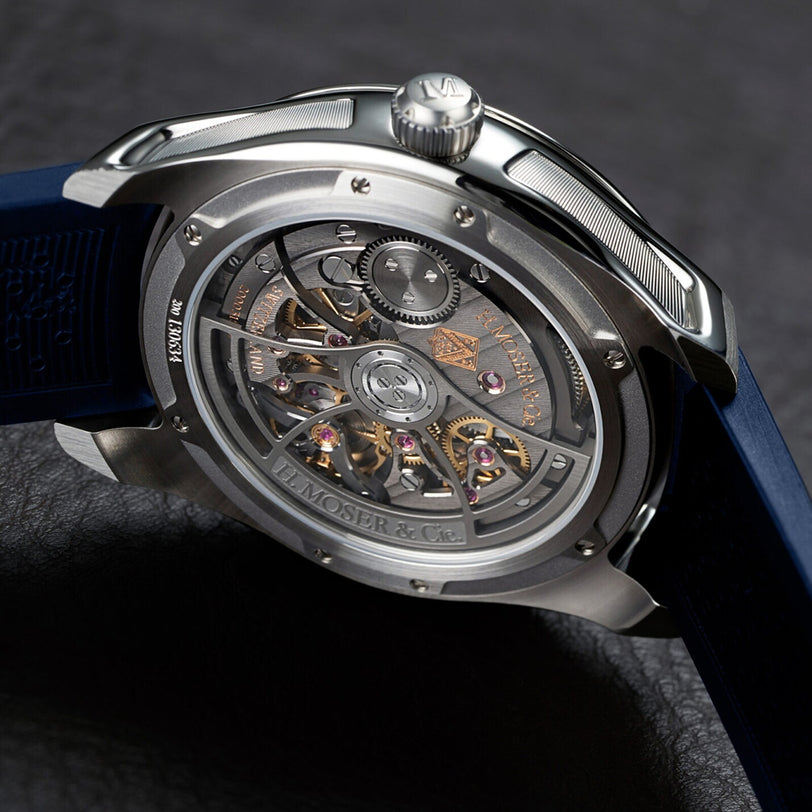 Close-up of the back of the H. Moser & Cie Pioneer Centre Seconds Concept Citrus Green luxury mechanical wristwatch, revealing its visible inner gears and blue strap.