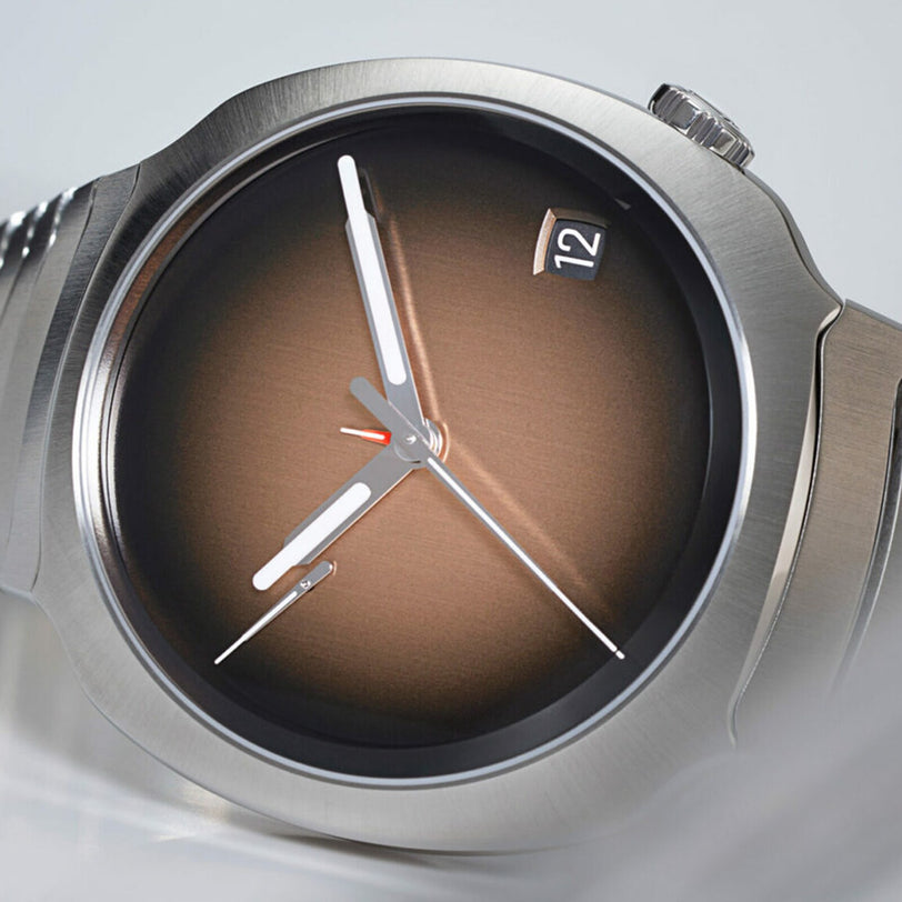 Close-up of the H. Moser & Cie Streamliner Perpetual Calendar, featuring a brown gradient dial, silver hands, and a date window displaying 12.