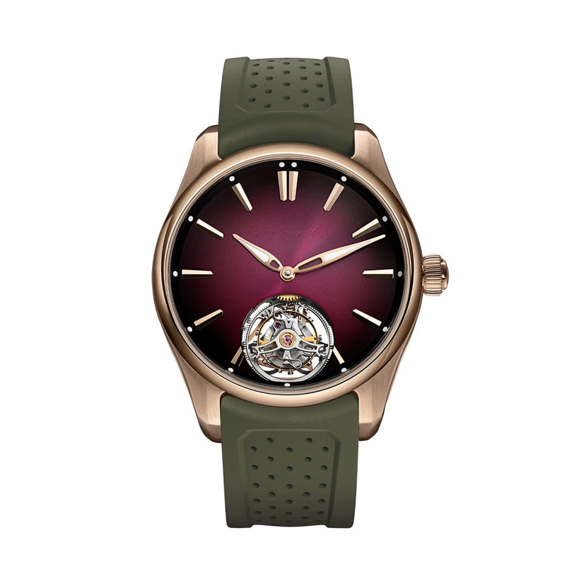 The H. Moser & Cie Pioneer Tourbillon Burgundy is a luxury watch featuring a burgundy dial, gold case, visible tourbillon, and green perforated strap.