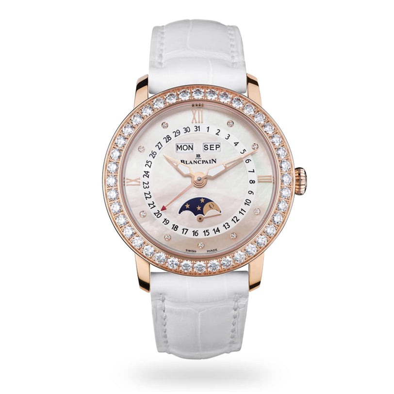 The Blancpain Ladybird Quantième Complet is a luxury wristwatch featuring a white strap, diamond bezel, day and month display, numbered date ring, and a mother-of-pearl dial with moon phase.