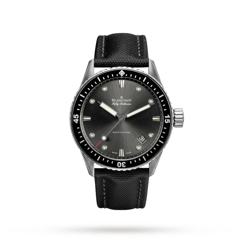 The Blancpain Fifty Fathoms Bathyscaphe is a black diver’s watch with a black bezel, dark dial, silver markers and hands, a black fabric strap, and an automatic 1315 calibre movement, shown on a white background.