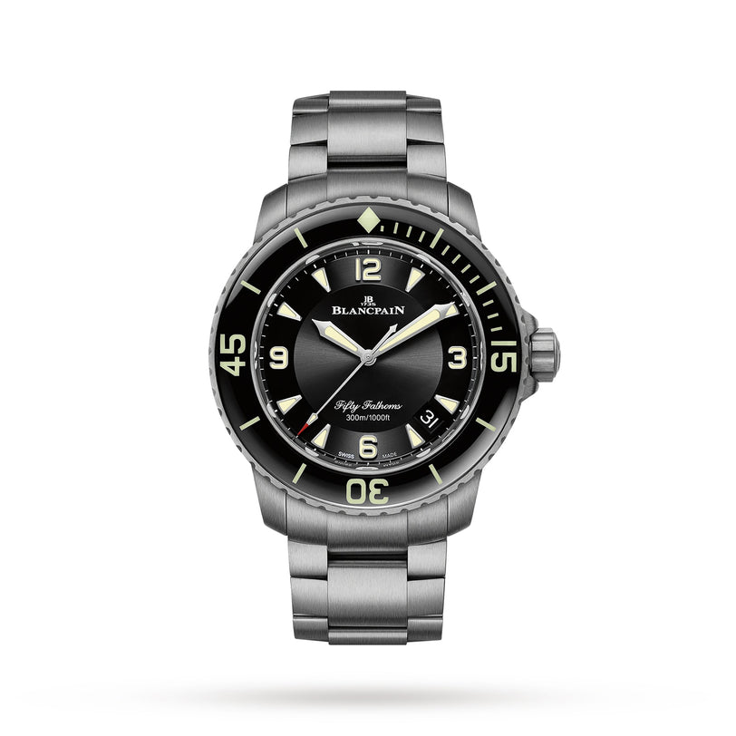 The Blancpain Fifty Fathoms Automatique is an automatic diver’s watch featuring a black dial, luminescent markers, and a date at 4 o’clock, shown on a metal bracelet against a white background. This watch redefines classic dive style.
