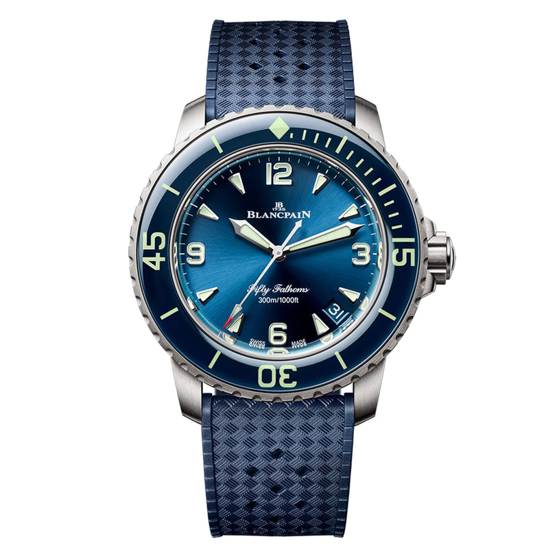The Blancpain Fifty Fathoms Automatique is a blue dive watch featuring a matching strap, luminous hands, and large numerals on the bezel.