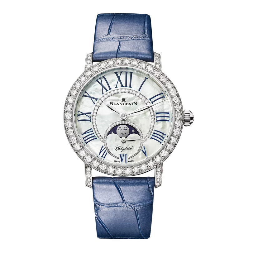 Blancpain Ladybird Colors Phases de Lune women’s watch with a diamond-set bezel, self-winding movement, blue leather strap, Roman numeral markers, and a moon phase display on a white dial.