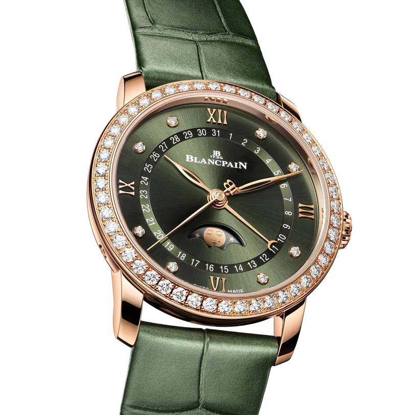 The Blancpain Villeret Quantième Phases de Lune is a luxury wristwatch featuring a green leather strap, diamond bezel, green dial, gold Roman numerals, and a moonphase display.