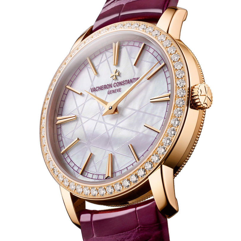The Vacheron Constantin Traditionnelle Manual-winding is a limited edition 18K pink gold watch featuring a diamond-studded bezel, textured white dial with gold markers, purple leather strap, and signature Vacheron Constantin branding on the face.