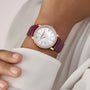 A wrist adorned with the limited edition Vacheron Constantin Traditionnelle Manual-winding 18K pink gold watch, set with diamonds, featuring a white dial and magenta leather strap, worn with a white long-sleeved garment.