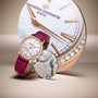 The Vacheron Constantin Traditionnelle Manual-winding, a limited edition 18K pink gold watch with a pink strap, is showcased before an oversized watch face and next to a detailed close-up of its internal mechanism.