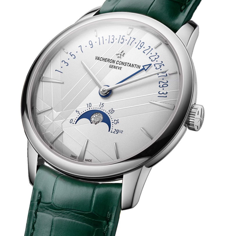 The Vacheron Constantin Patrimony Moon Phase Retrograde Date features an 18K white gold case, green leather strap, white textured dial, precision moon phase display, and retrograde date indicator.