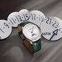 The Vacheron Constantin Patrimony Moon Phase Retrograde Date, a luxury wristwatch with a green leather strap, is showcased on blue-numbered discs, featuring a precise moon phase and calendar—an exquisite limited edition timepiece.