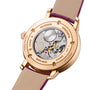Back view of the Vacheron Constantin Traditionnelle Moon Phase watch in pink gold, featuring an intricate mechanical movement visible through a transparent case back, engraved text, and a tan leather strap.