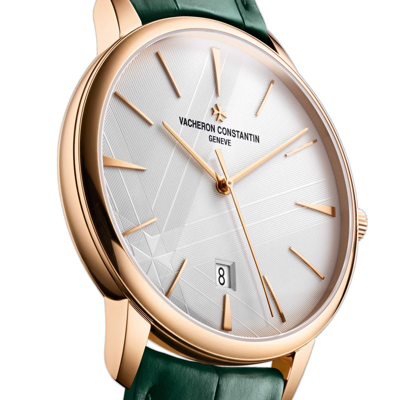 The Vacheron Constantin Patrimony Self-Winding features an 18K pink gold case, white patterned dial, gold hour markers, date at 6 o’clock, green leather strap, and bears the prestigious Geneva Seal.