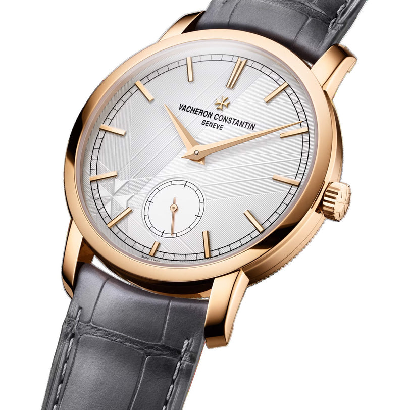 The Vacheron Constantin Traditionnelle Manual-winding is a limited edition wristwatch with an 18K pink gold case, silver dial, baton hour markers, small seconds subdial, and a gray leather strap.